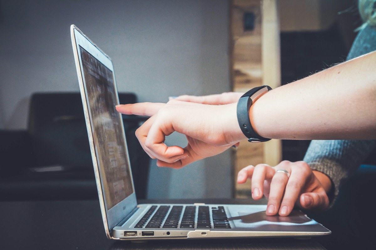 Two people reviewing content together on a laptop